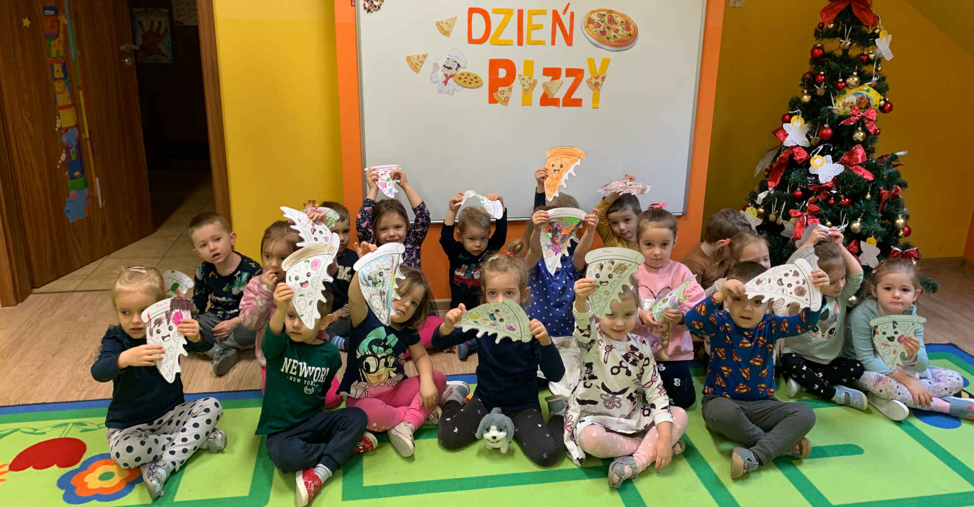 Zdjęcie grupowe dzieci z napisem Dzień Pizzy