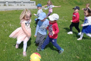 Dzieci na trawie grają w piłkę nożną