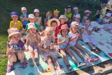 Dzieci siedzą na matach z lodami