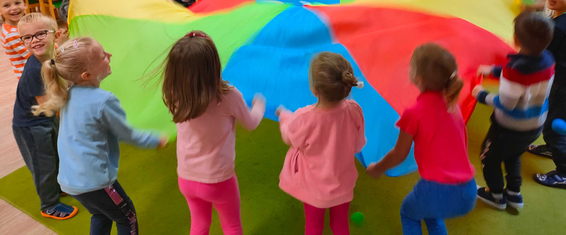 Dzieci podrzucają kolorowe koło